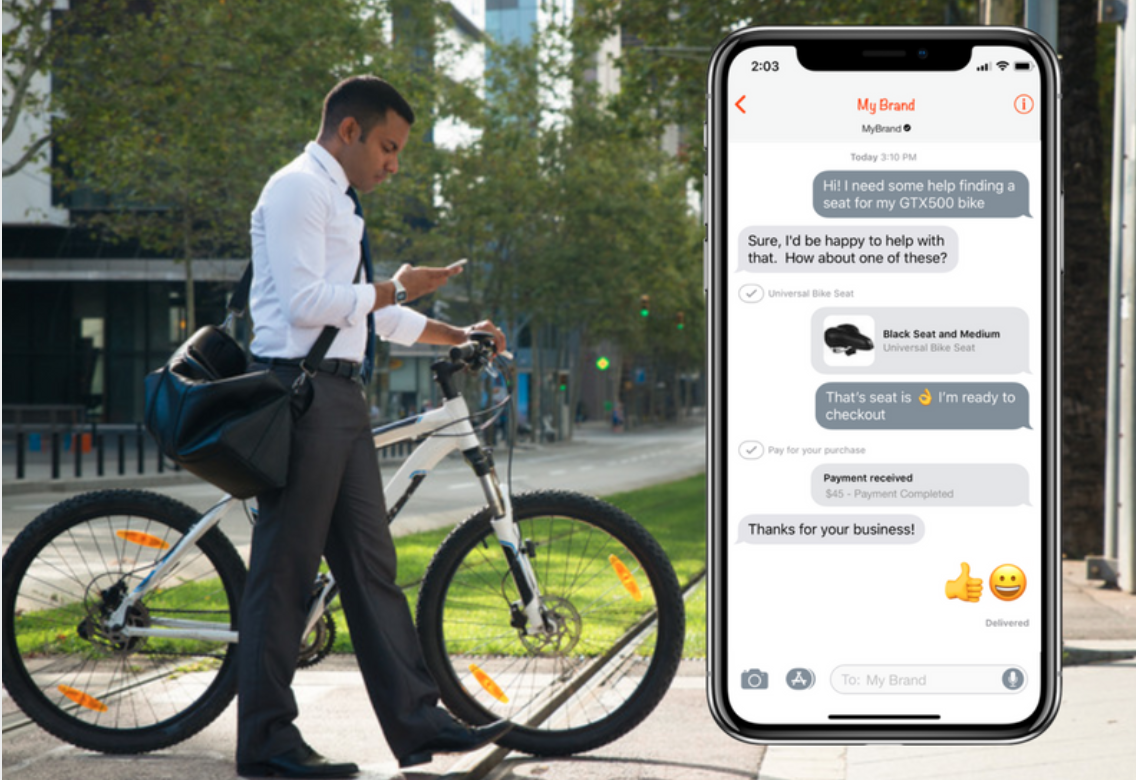 Business man texts customer service live while pushing his bike